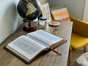 Bible posée sur une table avec un globe à côté